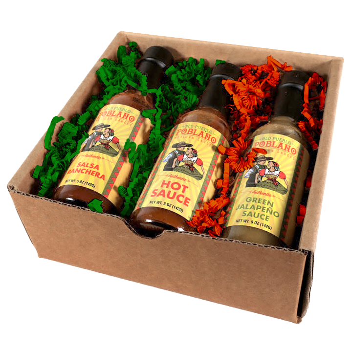 Three bottles of Poblano brand sauce in a cardboard box with decorative paper.